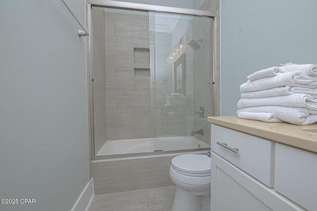 full bathroom with toilet, tile patterned floors, vanity, and bath / shower combo with glass door