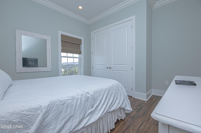 bedroom with ornamental molding, dark wood-type flooring, and a closet