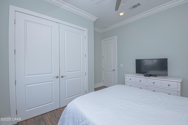 bedroom with crown molding, dark hardwood / wood-style floors, a closet, and ceiling fan