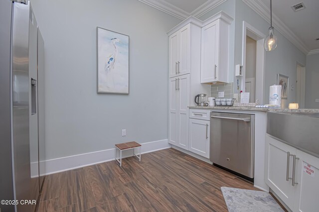 kitchen featuring appliances with stainless steel finishes, pendant lighting, white cabinetry, ornamental molding, and light stone countertops