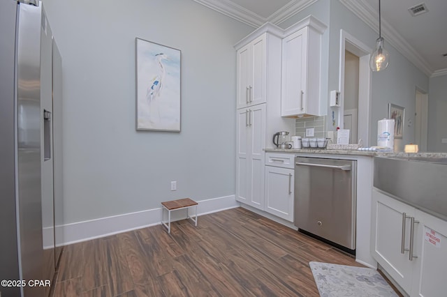 kitchen with appliances with stainless steel finishes, pendant lighting, white cabinets, crown molding, and light stone countertops