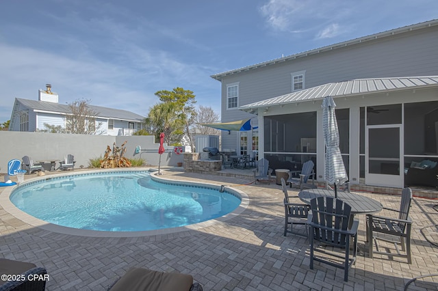 view of swimming pool featuring a patio and a sunroom