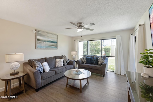 living room featuring ceiling fan, dark hardwood / wood-style flooring, and a textured ceiling