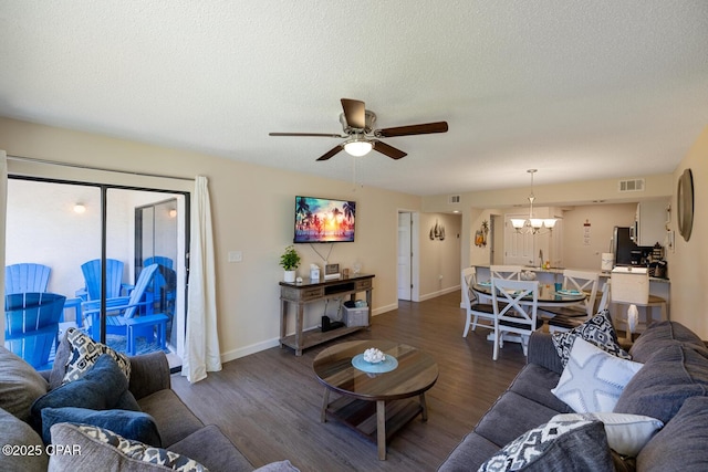 living room featuring dark hardwood / wood-style floors, ceiling fan with notable chandelier, a textured ceiling, and a wealth of natural light