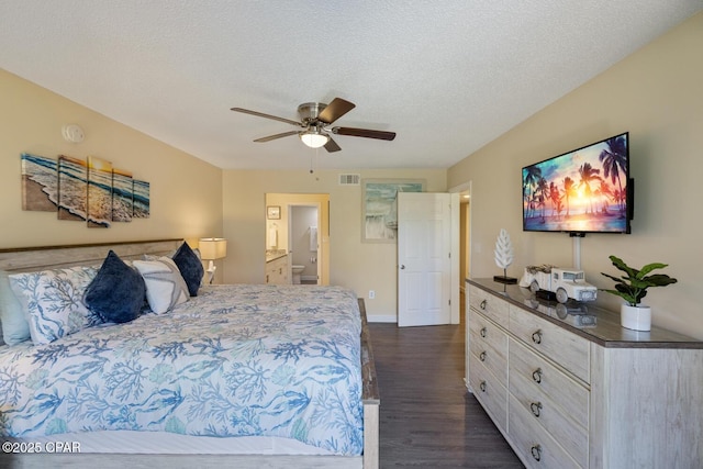 bedroom featuring ceiling fan, connected bathroom, dark hardwood / wood-style flooring, and a textured ceiling