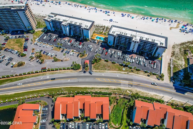 birds eye view of property featuring a beach view and a water view