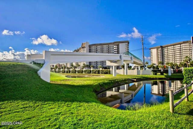 view of community featuring a water view and a lawn