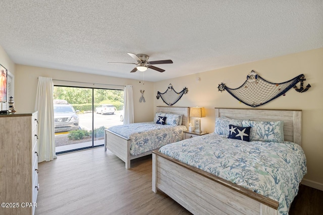 bedroom featuring access to exterior, a textured ceiling, ceiling fan, and light wood-type flooring