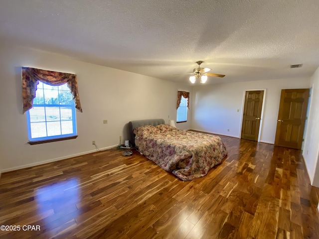 bedroom featuring a textured ceiling, dark hardwood / wood-style floors, and ceiling fan