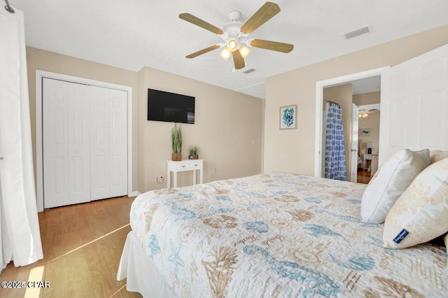 bedroom with ceiling fan, light wood-type flooring, and a closet