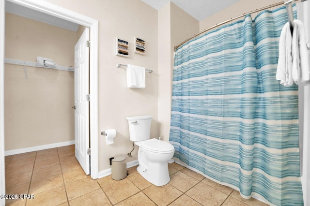 bathroom with a shower with curtain, tile patterned floors, and toilet