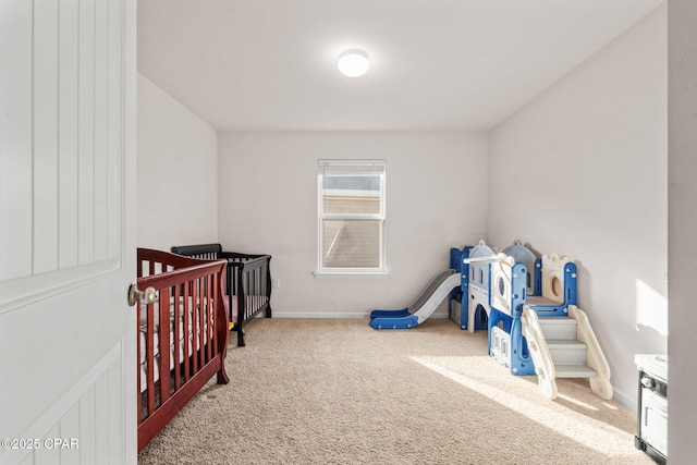 carpeted bedroom featuring baseboards and a nursery area