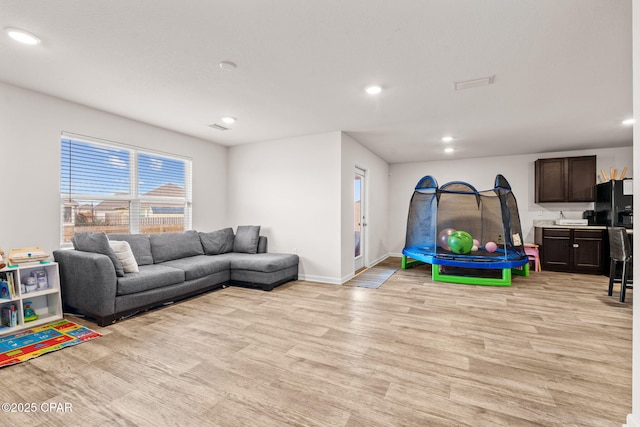 playroom featuring recessed lighting, baseboards, and light wood finished floors