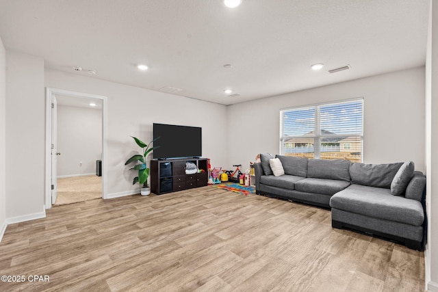 living room with visible vents, recessed lighting, light wood-style floors, and baseboards