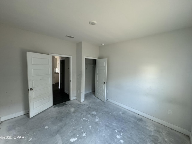 unfurnished bedroom featuring concrete floors and a closet