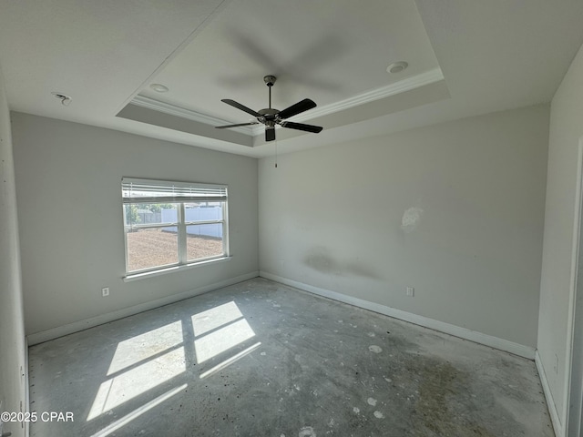 empty room featuring crown molding, ceiling fan, and a tray ceiling