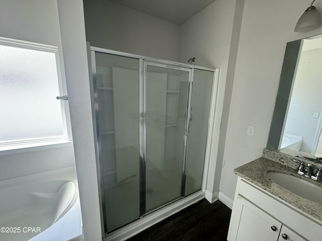 bathroom featuring vanity, independent shower and bath, and wood-type flooring