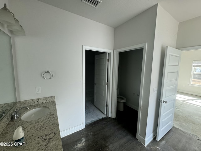 bathroom featuring vanity, concrete flooring, and toilet