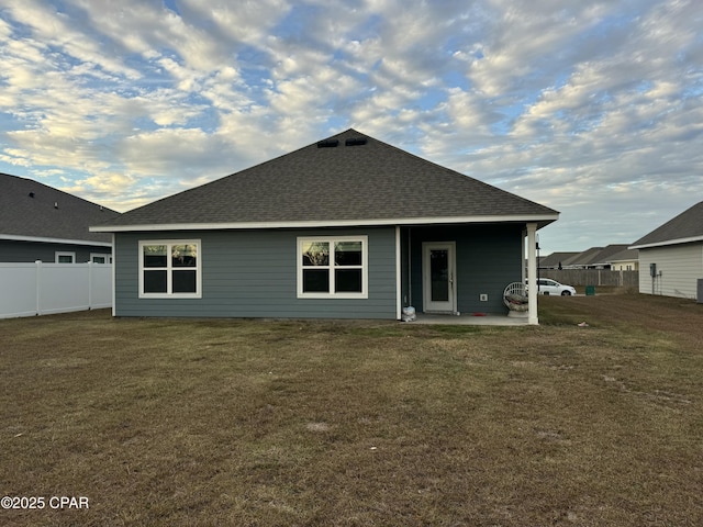 rear view of house with a patio and a lawn