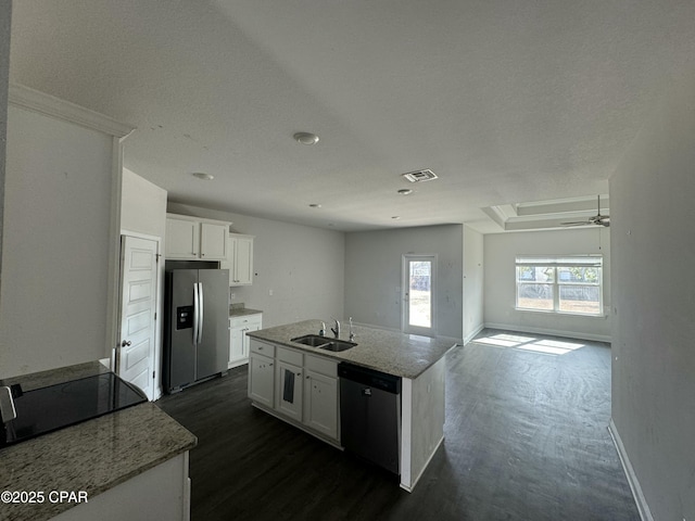 kitchen with sink, a center island with sink, appliances with stainless steel finishes, light stone countertops, and white cabinets