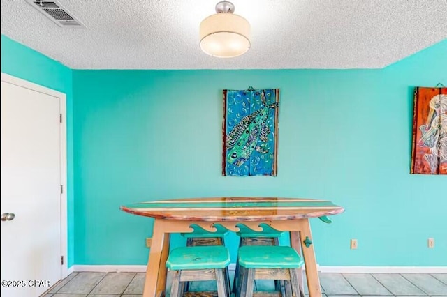 dining room with light tile patterned flooring and a textured ceiling