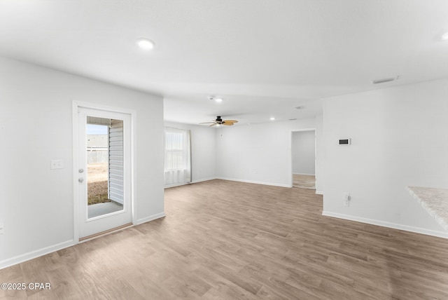 empty room with ceiling fan and light hardwood / wood-style floors