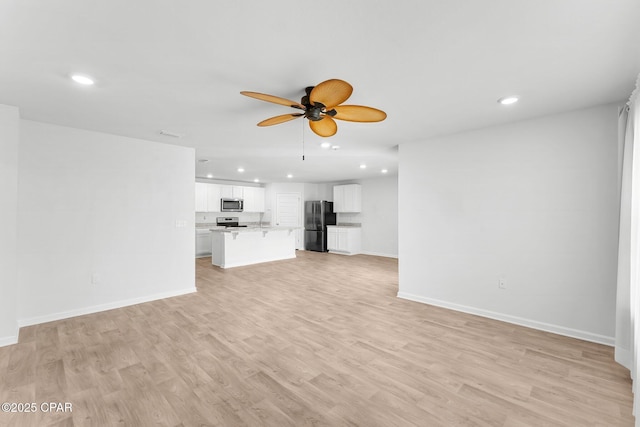 unfurnished living room featuring ceiling fan and light wood-type flooring