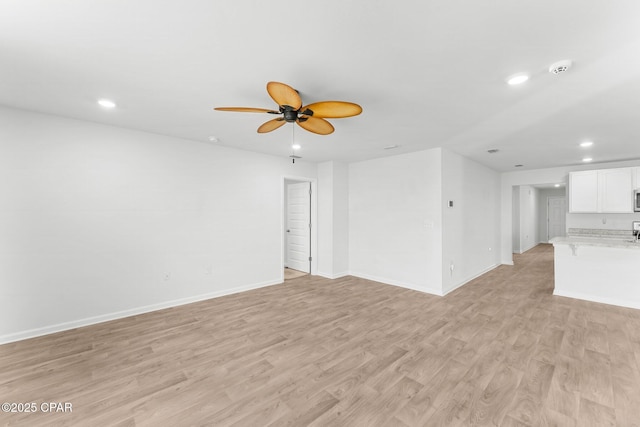 unfurnished living room featuring ceiling fan and light hardwood / wood-style flooring