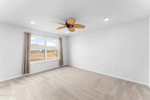 spare room featuring ceiling fan and light carpet