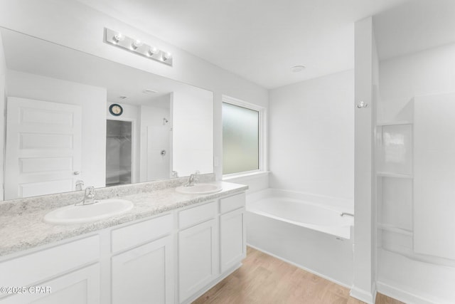 bathroom with vanity, a tub to relax in, and hardwood / wood-style flooring