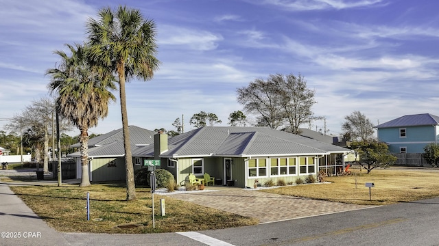 view of front of property featuring a sunroom and a front yard