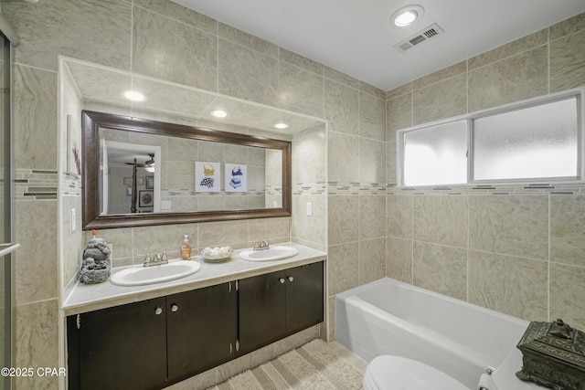 bathroom featuring vanity, tile walls, decorative backsplash, and toilet