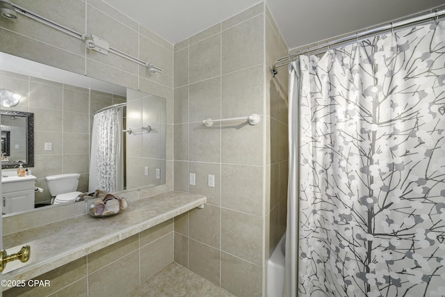 bathroom with vanity, toilet, and tile walls