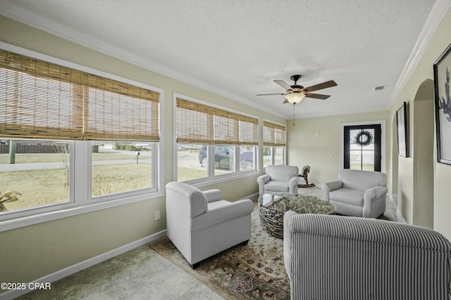 living room featuring ceiling fan, crown molding, and a textured ceiling