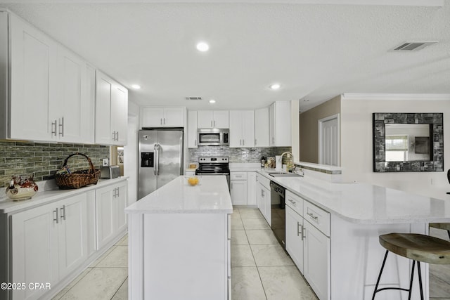 kitchen with white cabinetry, a breakfast bar, and appliances with stainless steel finishes