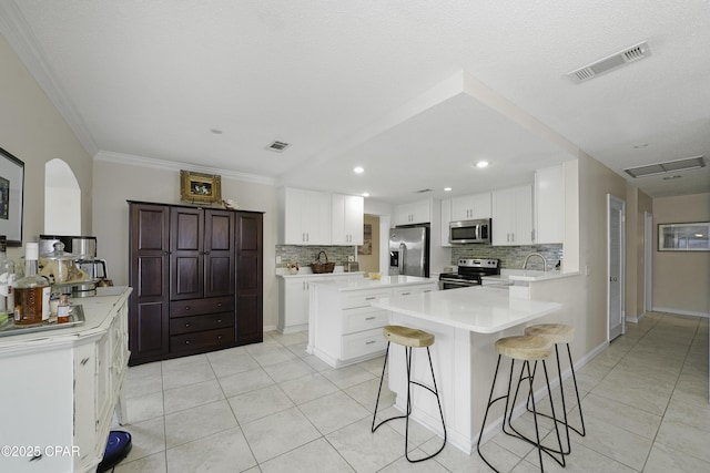 kitchen with white cabinetry, a breakfast bar area, stainless steel appliances, and a kitchen island