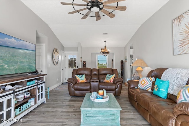 living room featuring vaulted ceiling and ceiling fan with notable chandelier