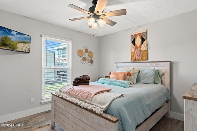 bedroom featuring multiple windows, hardwood / wood-style flooring, and ceiling fan