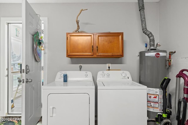 laundry area with cabinets, washing machine and clothes dryer, and water heater