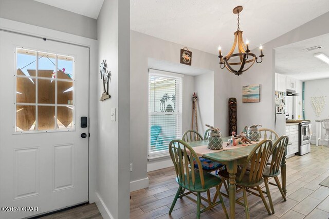 dining space with light hardwood / wood-style flooring and a chandelier