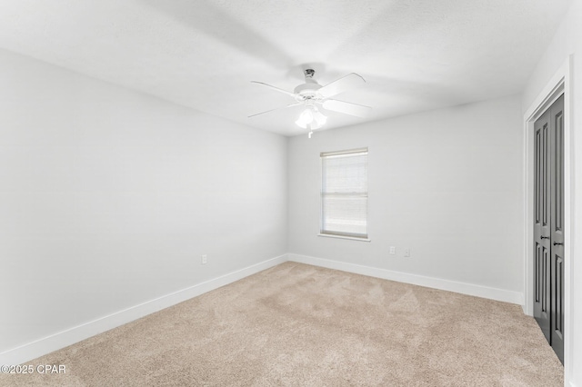 empty room featuring ceiling fan and carpet