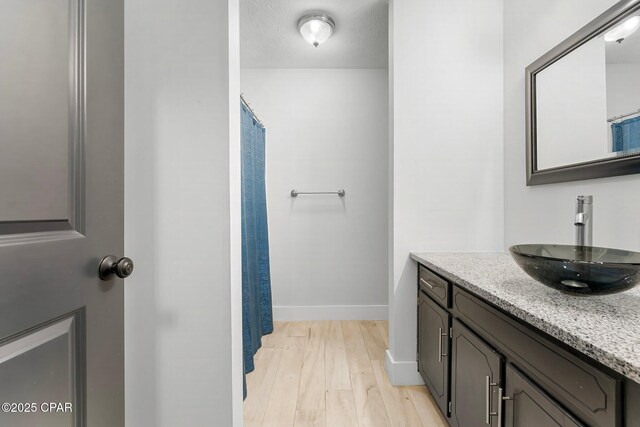 bathroom featuring hardwood / wood-style flooring, vanity, and a textured ceiling