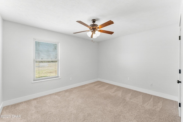 carpeted empty room featuring a textured ceiling, a ceiling fan, and baseboards