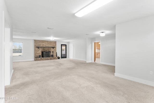 unfurnished living room featuring a brick fireplace and light colored carpet