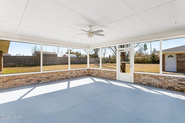 unfurnished sunroom featuring ceiling fan and a healthy amount of sunlight