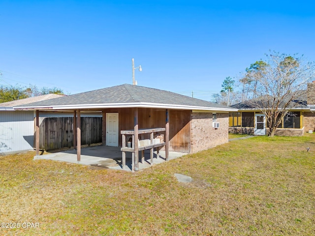 rear view of property with brick siding, fence, a lawn, and a patio