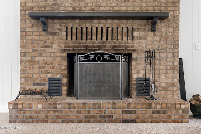 interior details featuring a brick fireplace and carpet floors