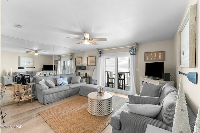 living room featuring ceiling fan and light wood-type flooring