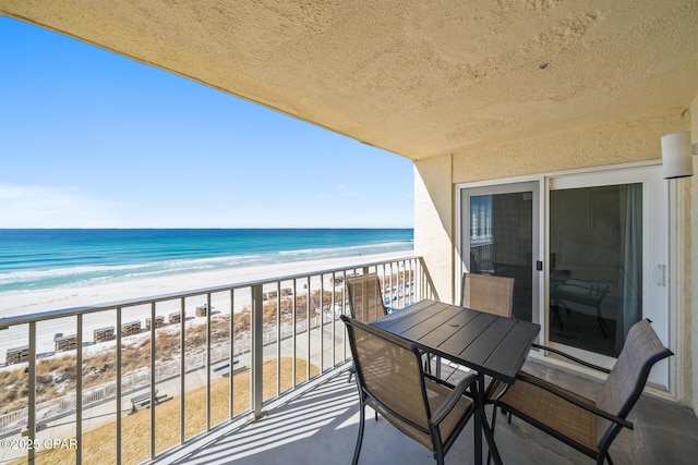 balcony featuring a water view and a beach view