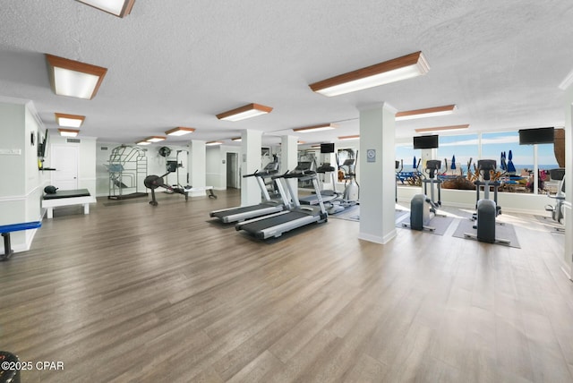 gym featuring a textured ceiling and wood finished floors